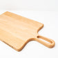 Medium size wood charcuterie board, made of light blonde Maple, with unique looped handle and exaggerated curves.