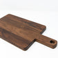 Small wood charcuterie board, made of dark Walnut, with a timeless rectangular shape and a straight handle.