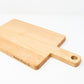 Small wood charcuterie board, made of light blonde Maple, with a timeless rectangular shape and a straight handle.