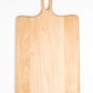 Medium size wood charcuterie board, made of light blonde Maple, with unique looped handle and exaggerated curves.