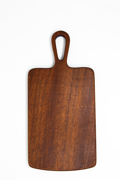 Extra small wood charcuterie board, made of a dark reddish-brown Sapele, with smooth curves and a unique teardrop handle.