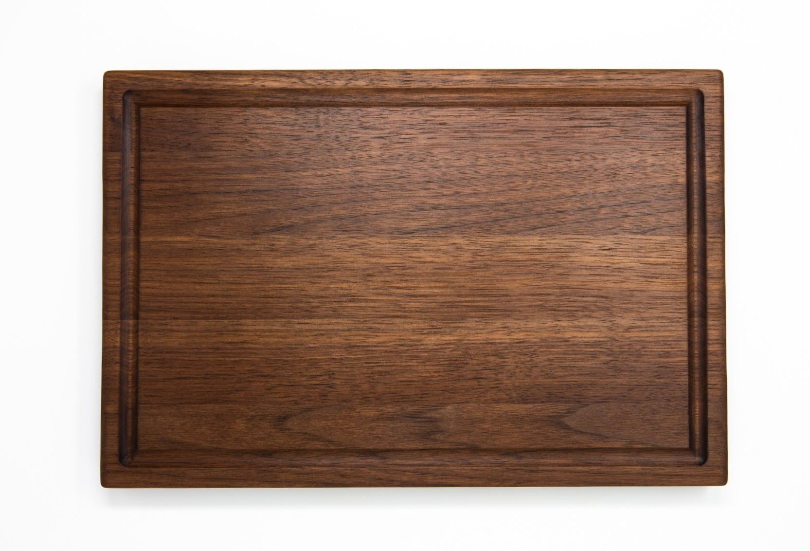 Medium size wood cutting board, made of dark walnut, with a juice groove and side handles.